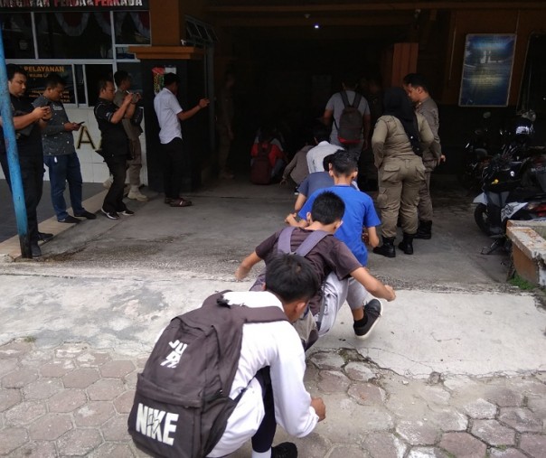 A total of 33 students skipping school walked squatting in the yard of the Pekanbaru Satpol PP Office, Monday (11/18/2019).