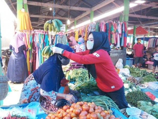 Head of Bagan Sienmbah Subdistrict put on mask to the traders who do not use masks 