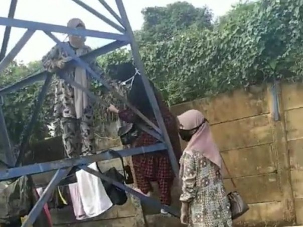 A man in Gowa with his three children climbed the tower for pilgrimage to the grave of a wife who was hit by Corona.