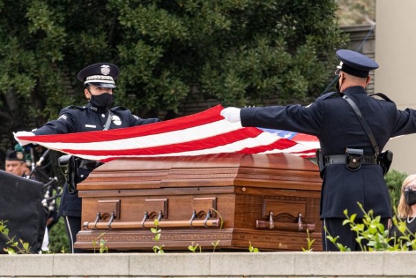 Officers remove the flag from the casket of LAPD Officer Valentin Martinez at the funeral service at Forest Lawn of Hollywood Hills